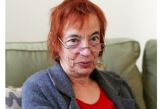 Photo of Lesley Stern with dyed red hair, looking over her glasses