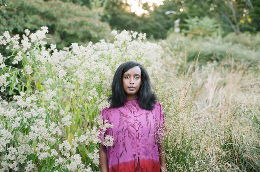Photo of Salome Asega in tall green grass