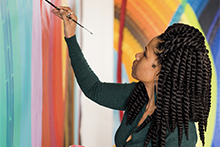 photo of the artist painting with bright colors